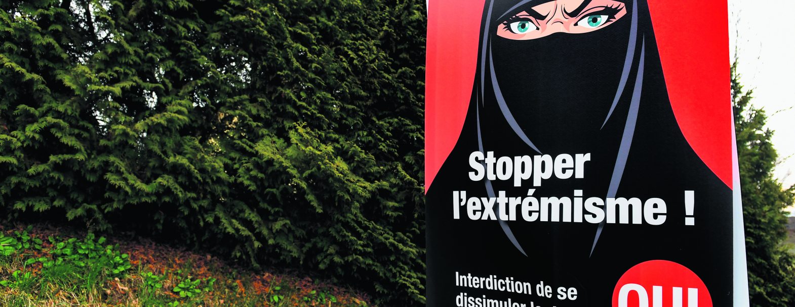 Vevey, le 7 mars 2021. Une affiche en faveur de l’interdiction de se dissimuler le visage acceptée par les électeurs suisses ce jour-là. Si le type de vêtements représentés est ultraminoritaire en Suisse, les promoteurs de l’initiative ont largement utilisé cette symbolique dans leur campagne. / © Shutterstock