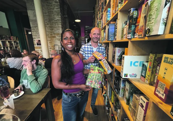 Les fondateurs de L’Amuse-Bar posent devant la ludothèque qui rassemble près de 2000 jeux de société. Photo: Khadija Froidevaux